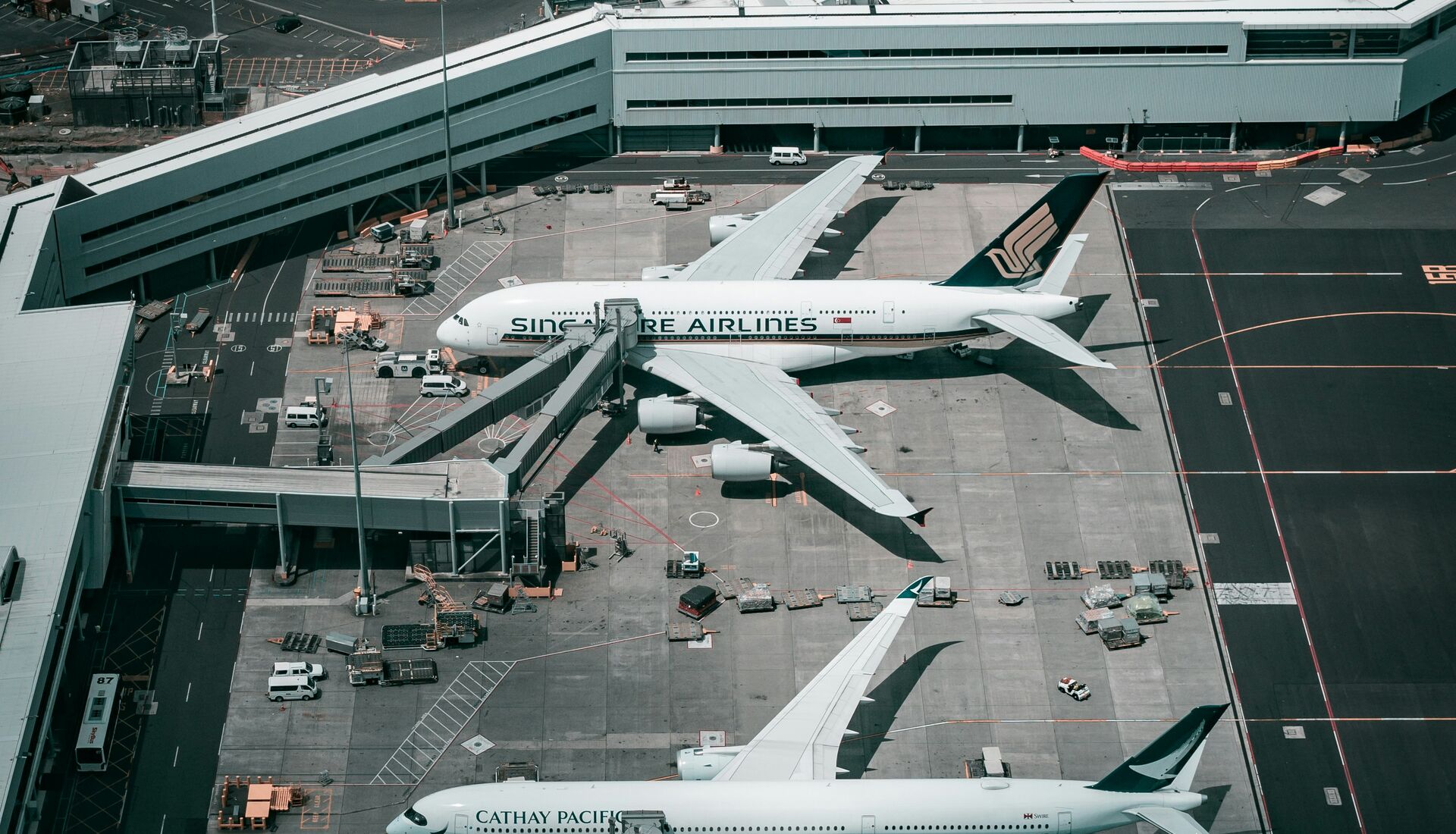 Aerial view of wide-body aircraft parked at airport gates, seen from above